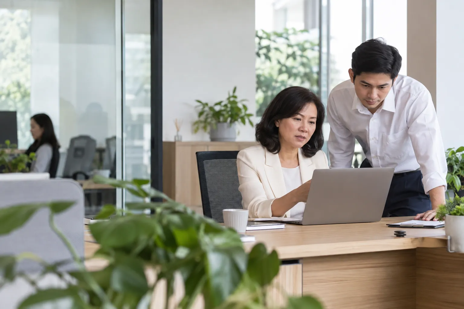 Trưởng phòng tài chính xem các đề xuất trên máy tính cùng kế toán